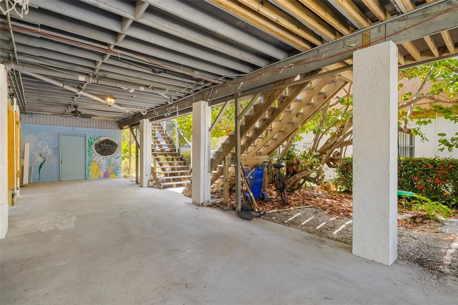 Large covered area below the home providing parking, storage, and flexible use space. - 2513 AVENUE B #B, BRADENTON BEACH