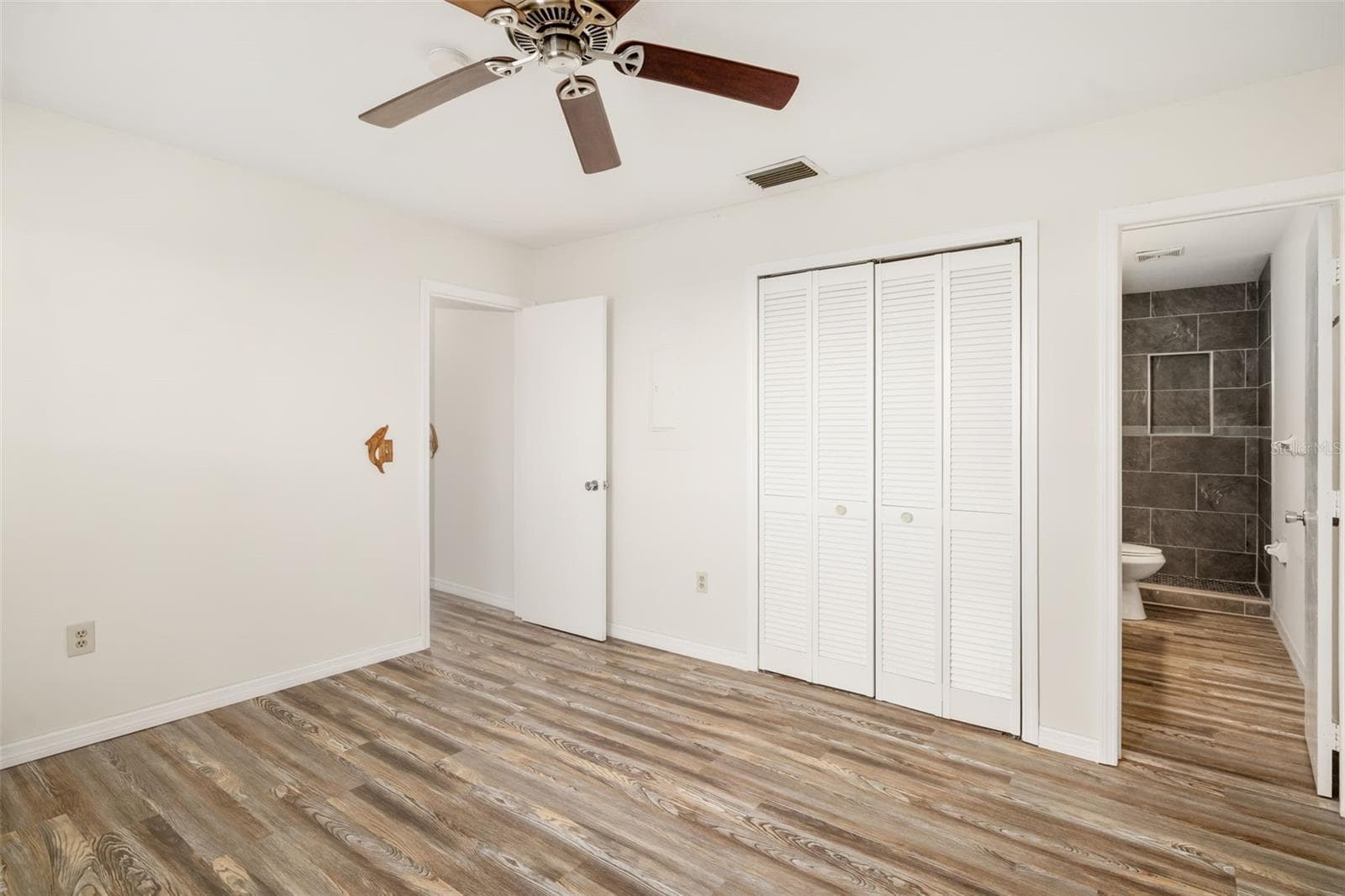 Bedroom featuring built-in storage and closet system for added organization. - 2513 AVENUE B #B, BRADENTON BEACH