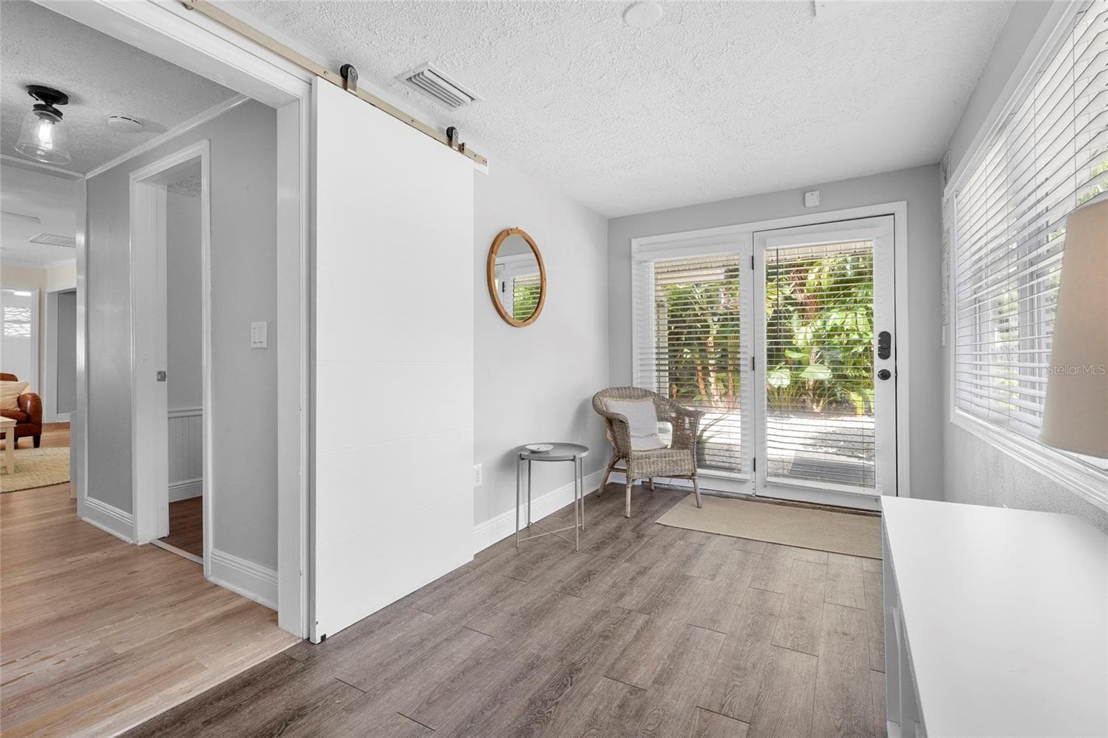 Bright and Airy Entry – Step into a sun-drenched Florida room featuring luxury vinyl flooring and a wall of windows—ideal as a reading nook, guest landing zone, or flex workspace. - 2705 2ND AVE W, BRADENTON