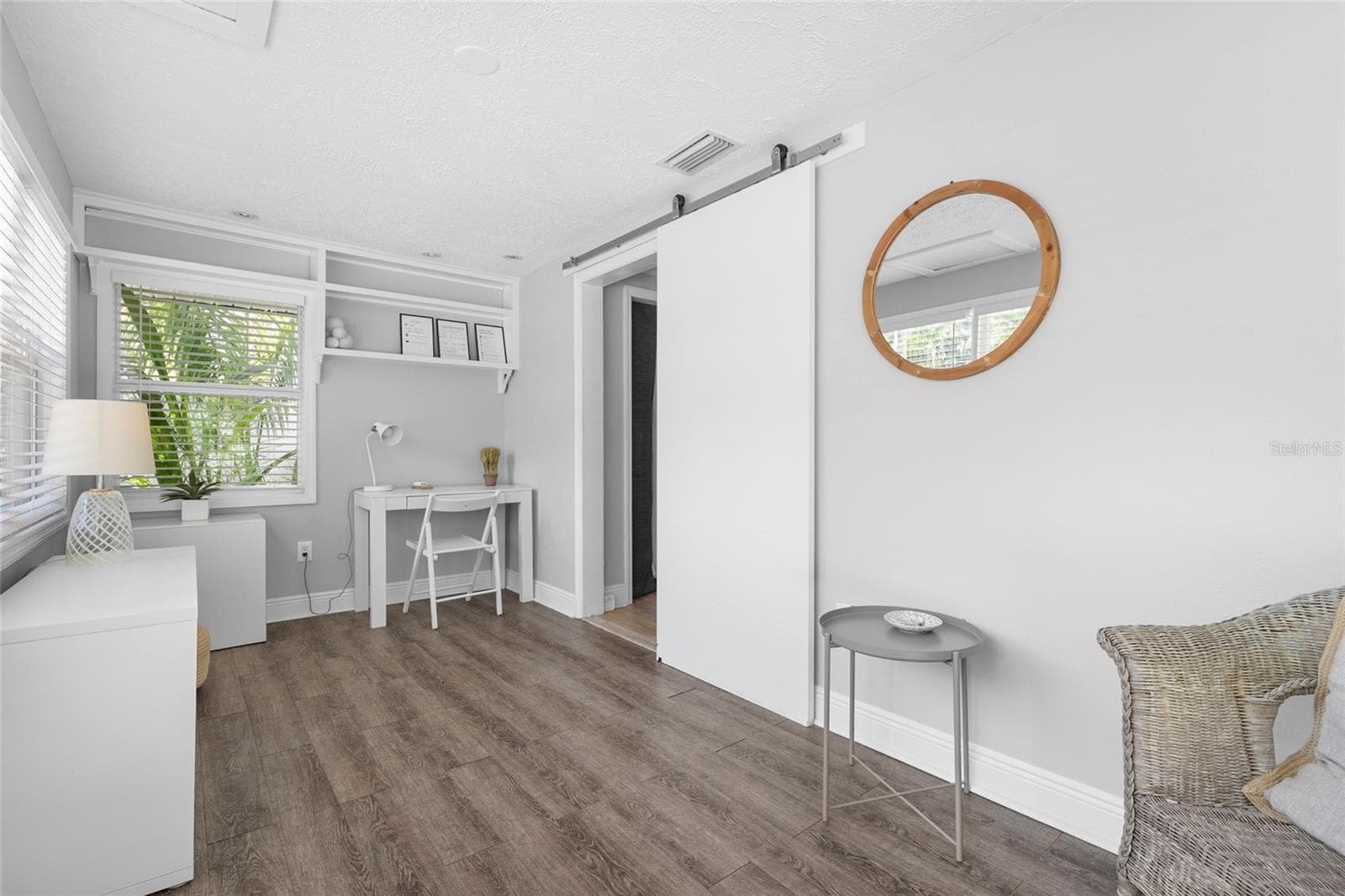 Bright and Airy Entry – Step into a sun-drenched Florida room featuring luxury vinyl flooring and a wall of windows—ideal as a reading nook, guest landing zone, or flex workspace. - 2705 2ND AVE W, BRADENTON
