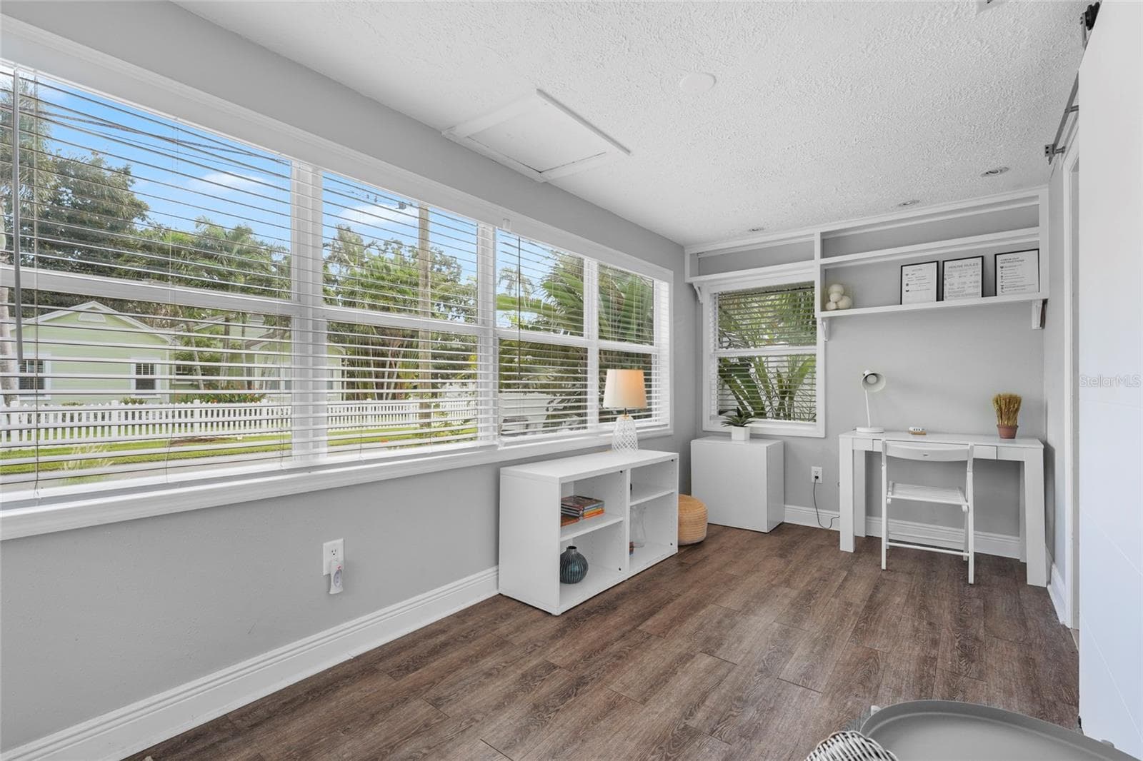 Bright and Airy Entry – Step into a sun-drenched Florida room featuring luxury vinyl flooring and a wall of windows—ideal as a reading nook, guest landing zone, or flex workspace. - 2705 2ND AVE W, BRADENTON