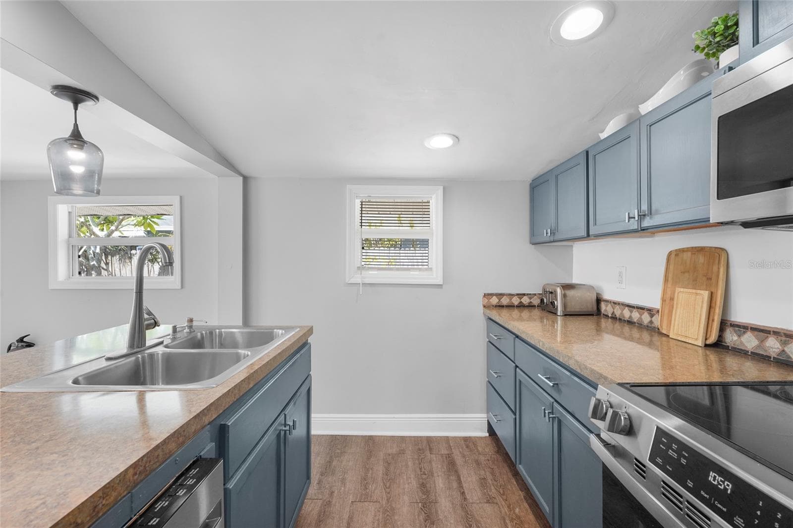 Updated Kitchen – Enjoy stainless steel appliances (2024/2025), ample storage, and classic blue cabinetry in a space that blends functionality with charm. - 2705 2ND AVE W, BRADENTON