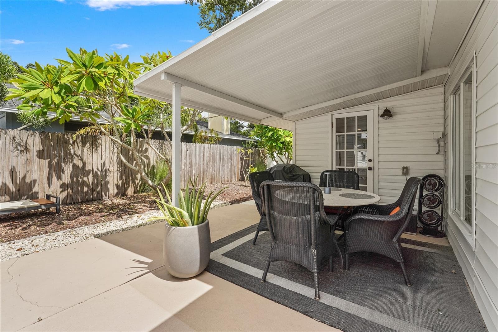 Covered Dining Patio – Dine alfresco under a covered lanai complete with fan, grill station, and cozy all-weather seating—a must-have feature for guests or year-round Florida living. - 2705 2ND AVE W, BRADENTON