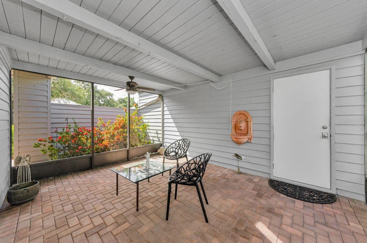 The breezeway next to garage, with brick pavers and the door into the garage. What a great private space! - 10479 LONGWOOD DR, SEMINOLE