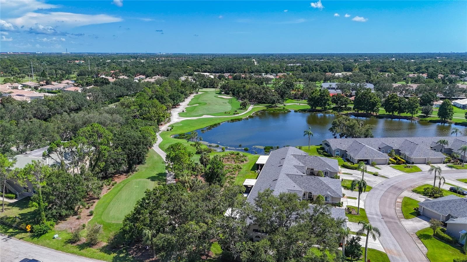 Aerial view of 8th fairway, with the natural green space between the golf course and the rear of the villas. - 6948 STONEYWALK CT, BRADENTON