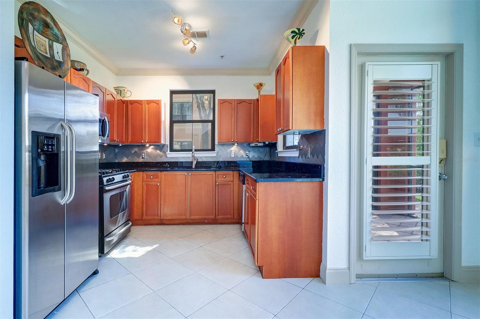 View of the kitchen from the breakfast nook/door to the right goes out to the screened lanai/porch - 2757 VIA CIPRIANI #1114A, CLEARWATER