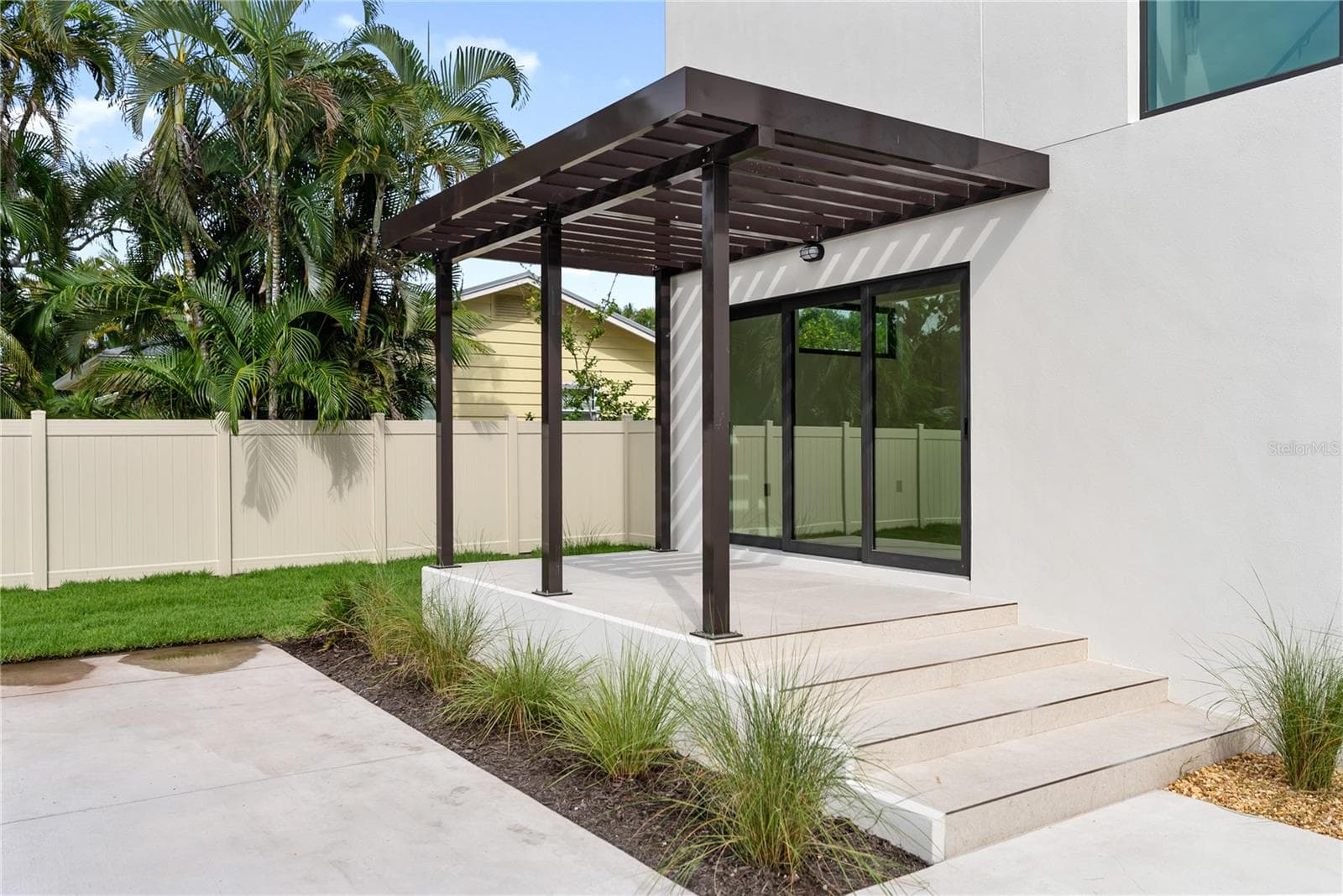 Front patio with elegant trellis detail and direct access to the office through sliding glass doors - 1759 WALDEMERE ST, SARASOTA