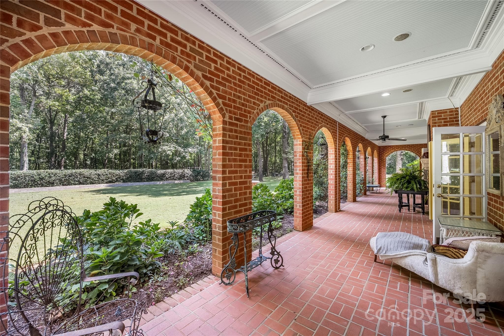 Lower-level covered patio leads you onto the beautifully landscaped yard with raised garden beds, rose bushes and chicken coop. - 2665 Rolling Hills Drive, Monroe
