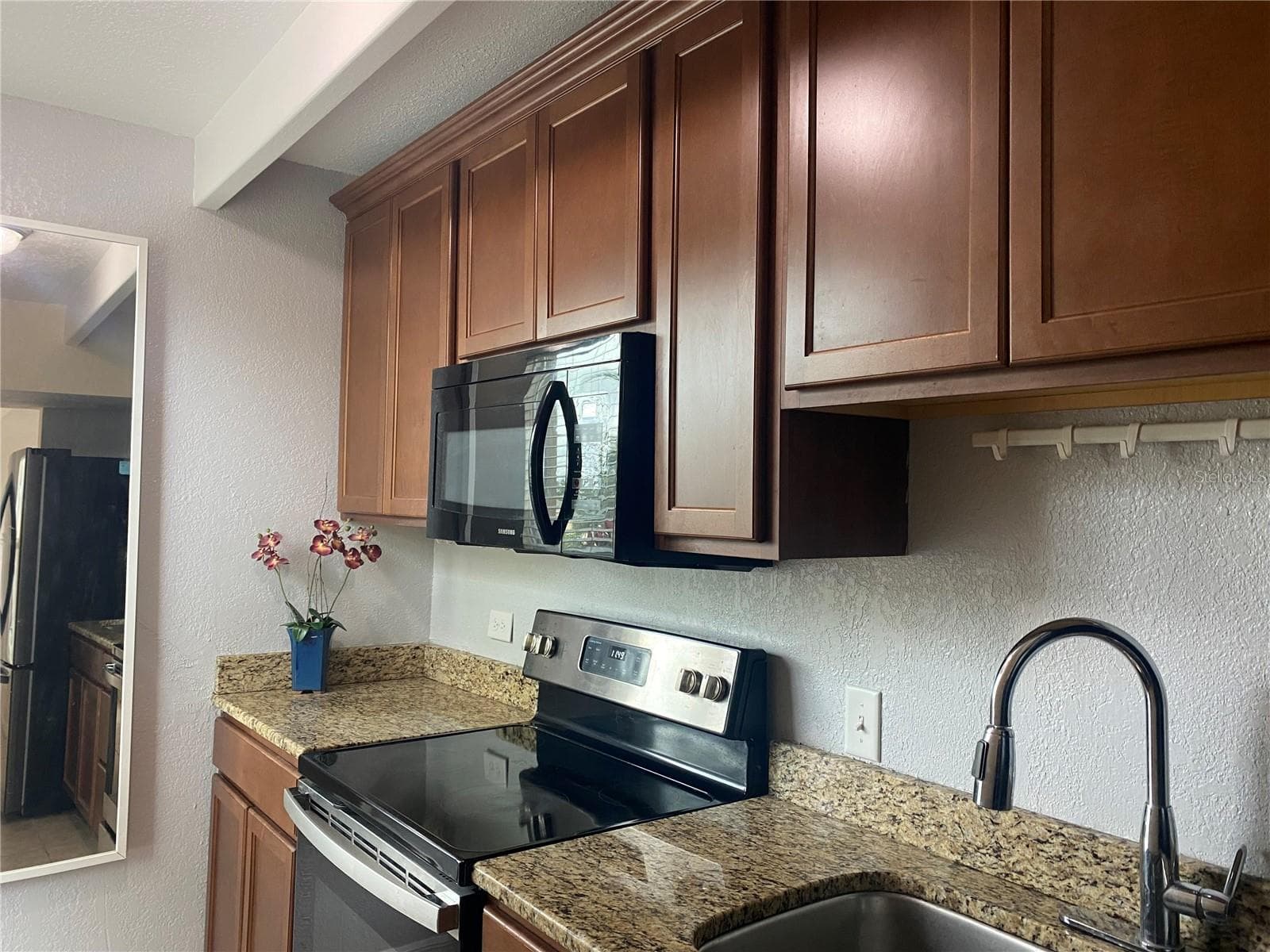 The galley kitchen has beautiful wood cabinetry. - 4409 CLUB CIR, LAKE WALES