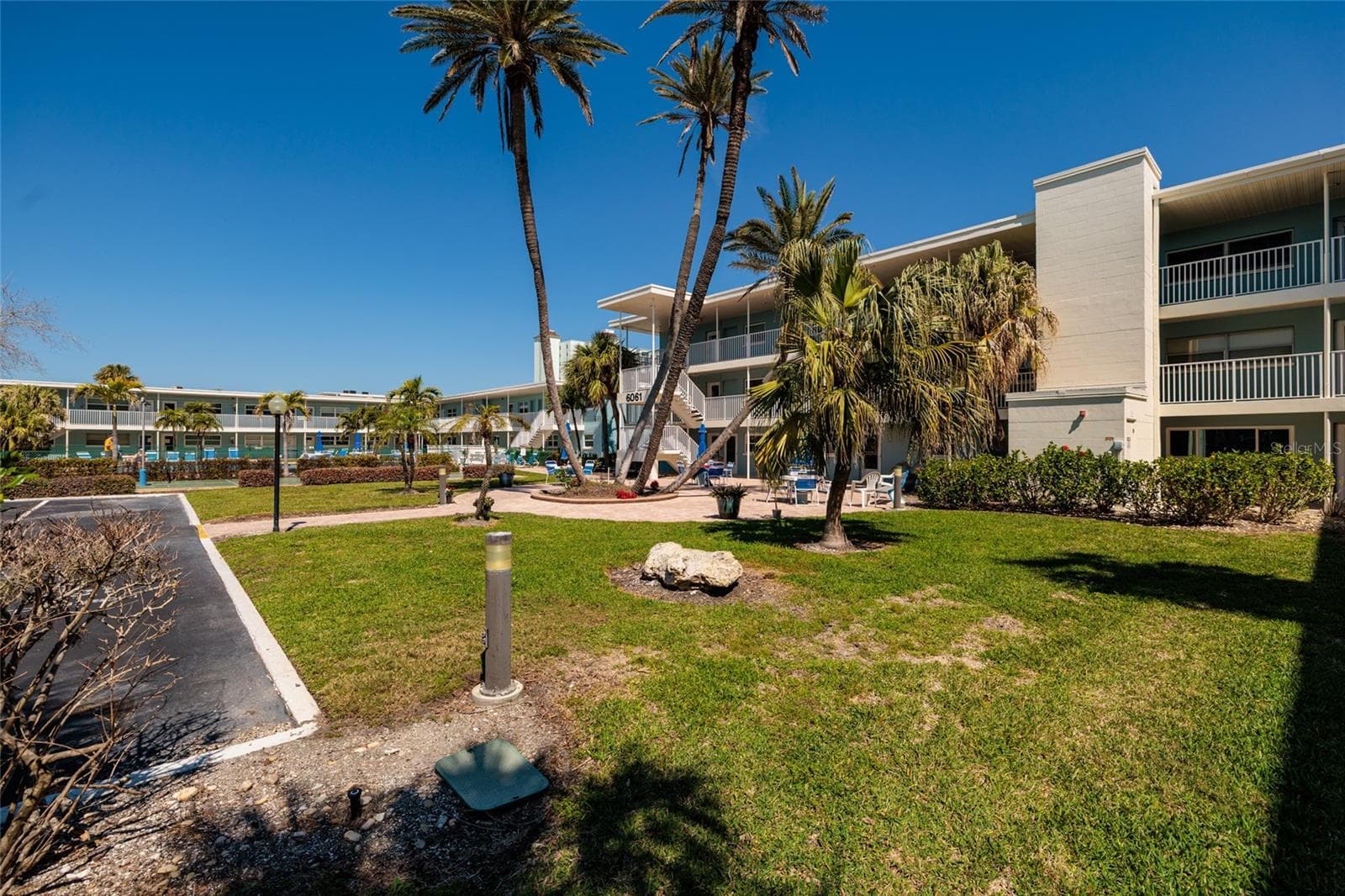 Courtyard w/Beautiful palm trees in front of the unit. - 6061 2ND ST E #55, ST PETE BEACH