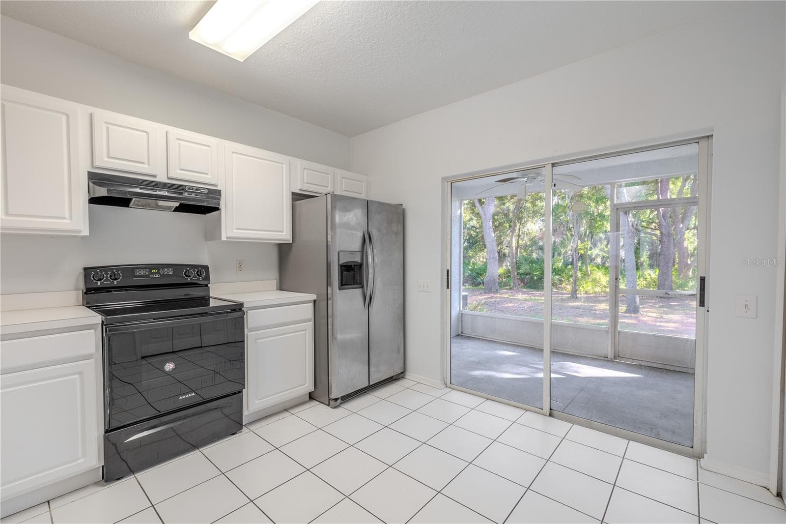 The kitchen features neutral tone cabinets and countertops, and a stainless steel dishwasher. There is a laundry closet with washer/dryer. - 2432 LAKE WOODBERRY CIR, BRANDON