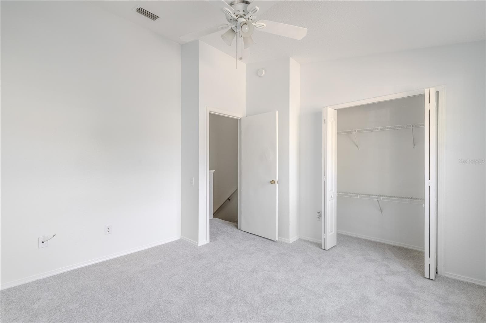 The 2nd bedroom features carpet, a ceiling fan with light kit and vaulted ceiling. - 2432 LAKE WOODBERRY CIR, BRANDON