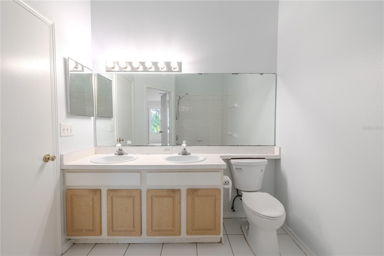 Shared 2nd floor bathroom features a mirrored vanity with dual sinks and storage, ceramic tile floor and a tub with shower. - 2432 LAKE WOODBERRY CIR, BRANDON