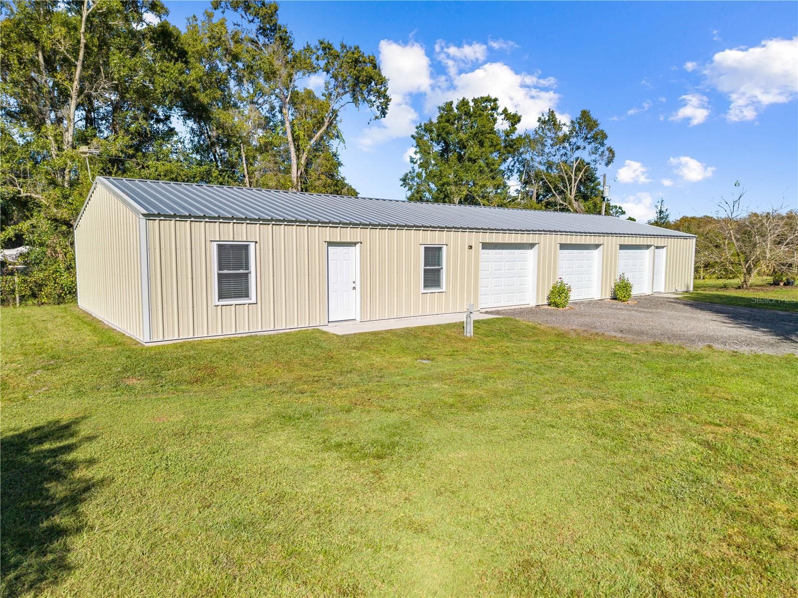 garage with bathroom, a/c, attic space, electric and water that is attached to the in-law suite. The in-law suite front door is between the windows and the one car garage private entrance is the 1st bay. - 4055 EDSEL AVE, ST CLOUD