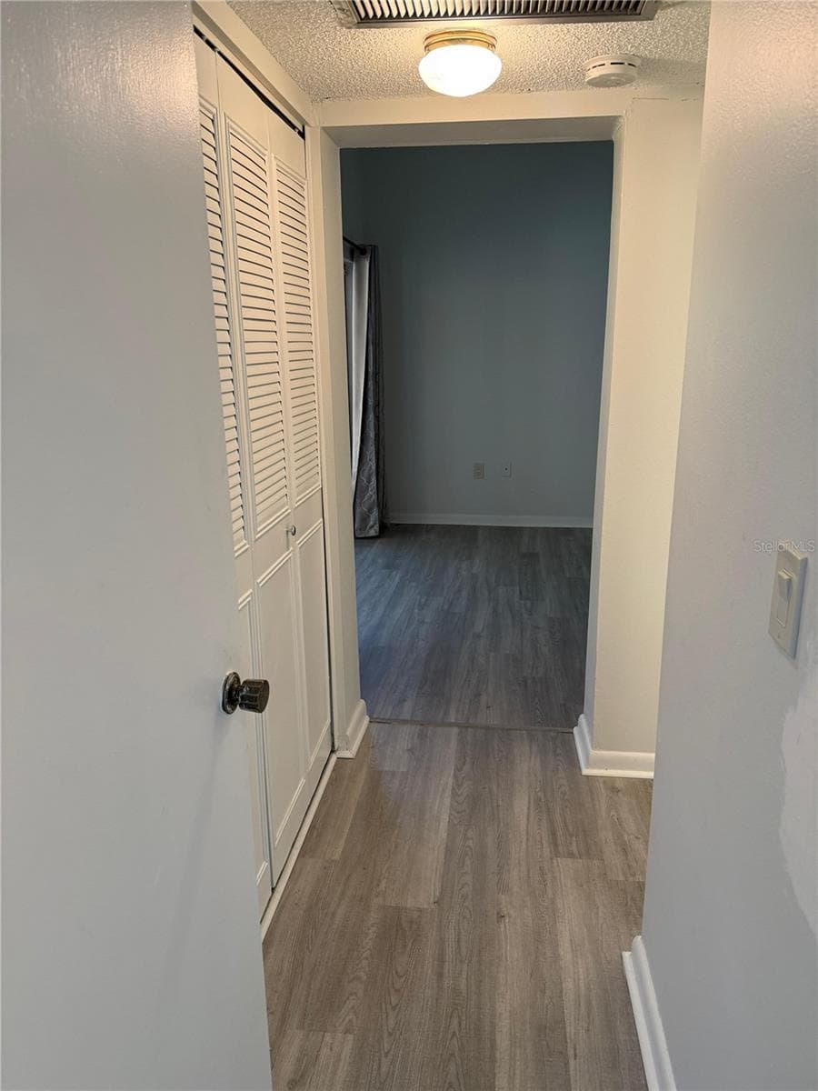 Hall to the primary bedroom, large closet on your left, updated bathroom on your right. - 2207 BELLEAIR RD #B22, CLEARWATER