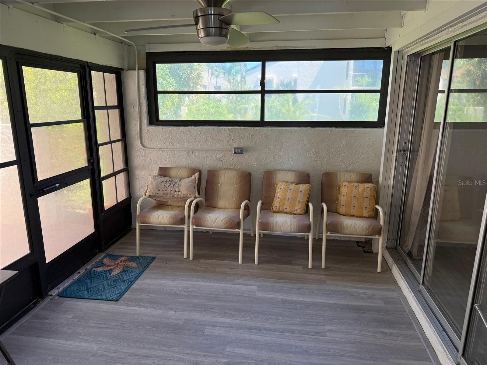 View from the dining area to the Florida room the primary bedroom on your right, the patio out the door to your left. Ceiling fan included. plenty of early morning light comes into your unit from here! - 2207 BELLEAIR RD #B22, CLEARWATER