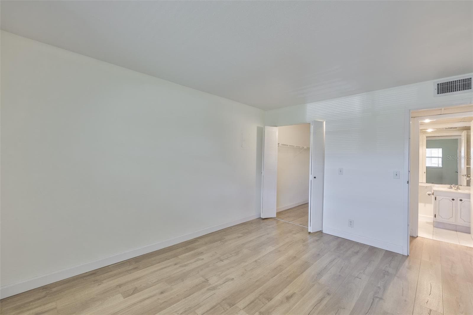 Primary bedroom, walk-in closet left, primary bath right and hallway - 1811 BEDFORD LN #153, SUN CITY CENTER