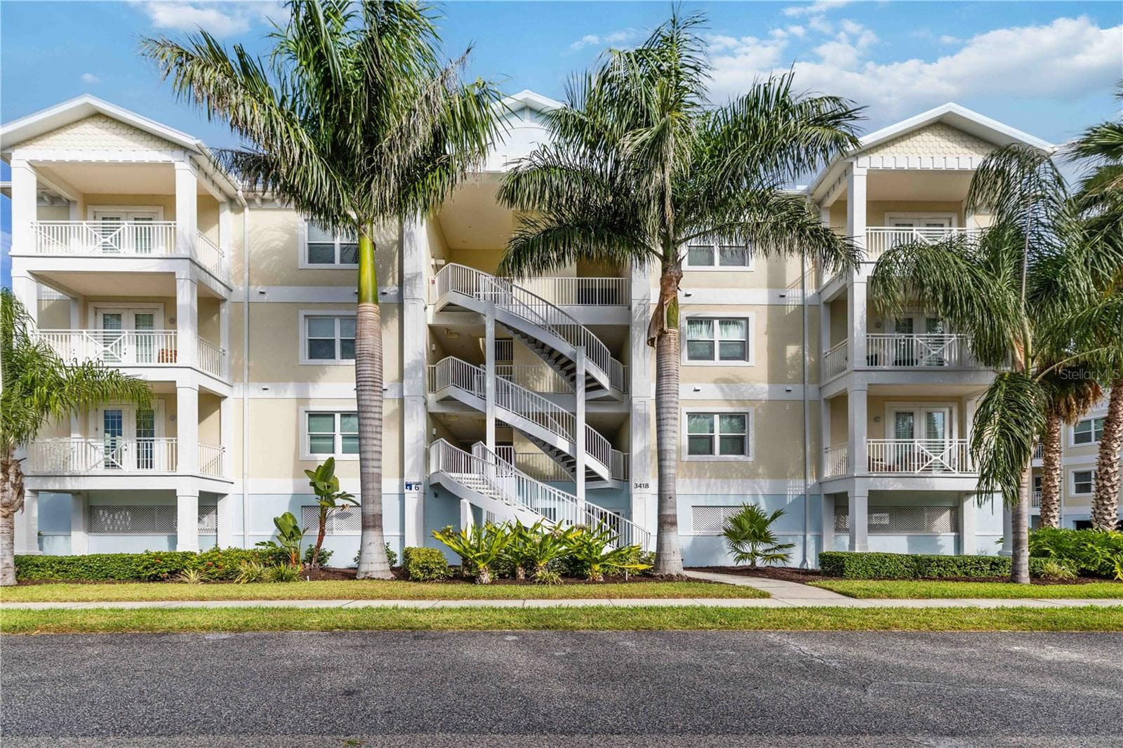 Palm-lined condominium building exterior - 3418 79TH STREET CIR W #101, BRADENTON