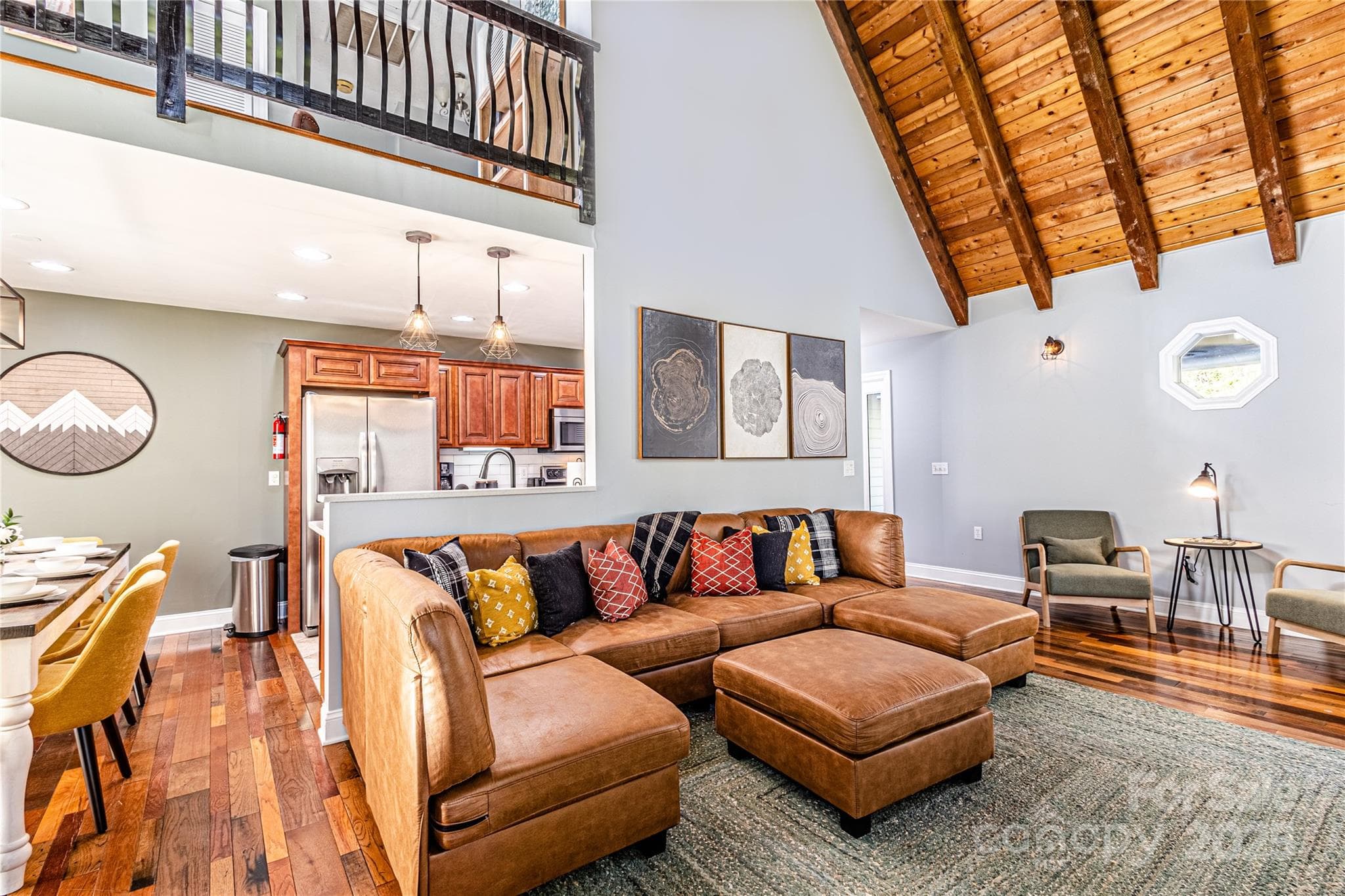 vaulted space, with the loft looking down towards the fireplace and the tall windows - 540 Toot Hollow Road, Bryson City