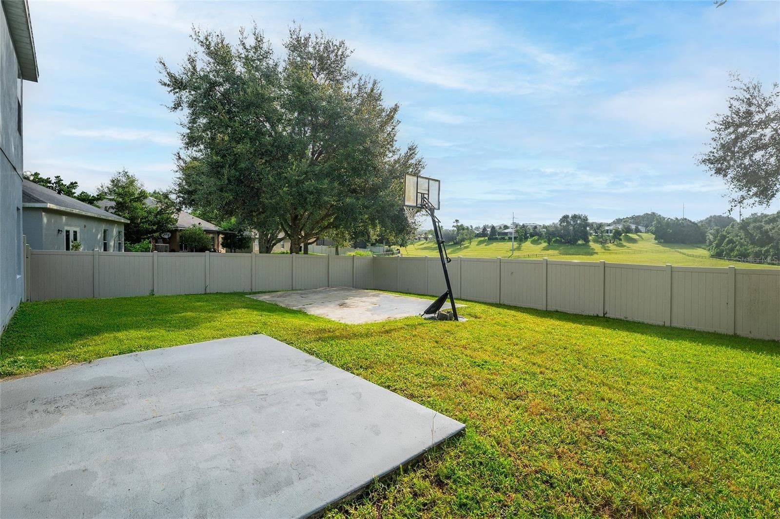 The oversized private fenced yard overlooks the greenbelt and features a half court basketball area - 20930 SULLIVAN RANCH BLVD, MOUNT DORA