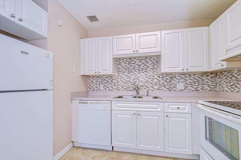 Fully equipped Kitchen featuring white cabinets, appliances, beautiful backsplash and countertops - 13693 ORANGE SUNSET DR #203, TAMPA