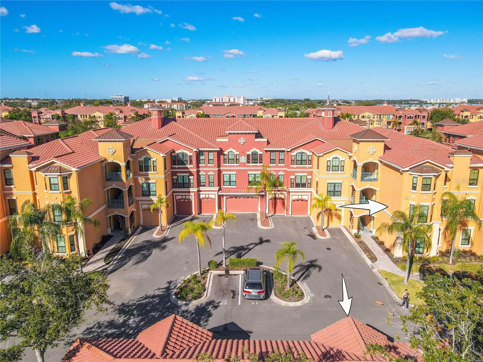 A vibrant Mediterranean-style enclave unfolds beneath blue skies, where palm-lined courtyards and elegant façades set the stage for resort-inspired living in this second floor condo with deeded garage as shown at The Grand Bellagio. - 2738 VIA TIVOLI #220B, CLEARWATER