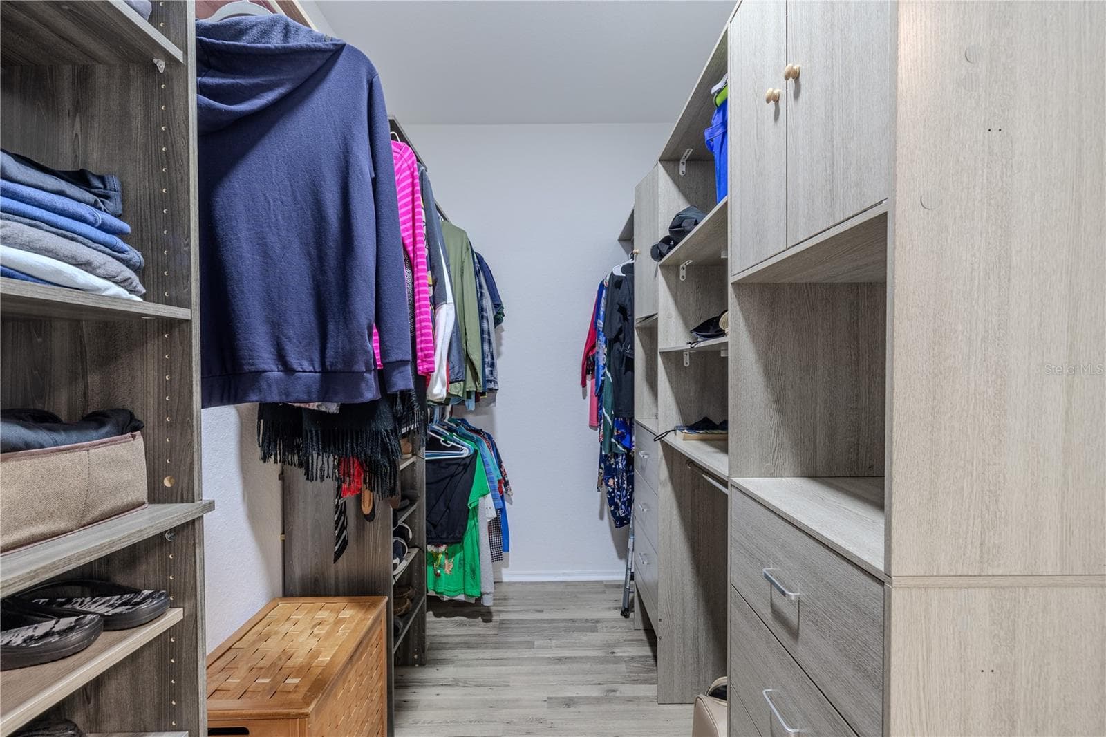 This view highlights the convenient layout of the primary suite, with the bedroom flowing into a well-appointed en-suite bath that seamlessly connects to an expansive walk-in closet with custom shelving and abundant storage. - 2738 VIA TIVOLI #220B, CLEARWATER