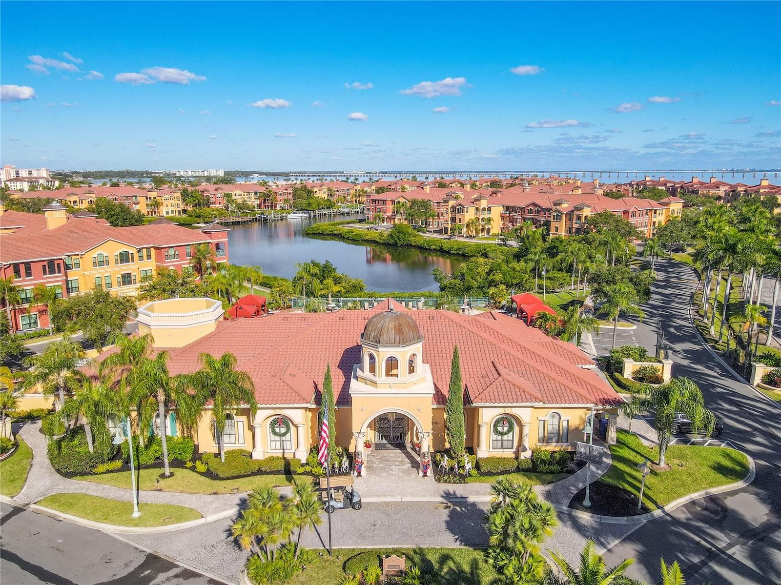 The grand clubhouse anchors the community with a stunning resort-style pool, twin sun-shelf basins, and palm-lined lounging areas designed for both relaxation and social gatherings. - 2738 VIA TIVOLI #220B, CLEARWATER