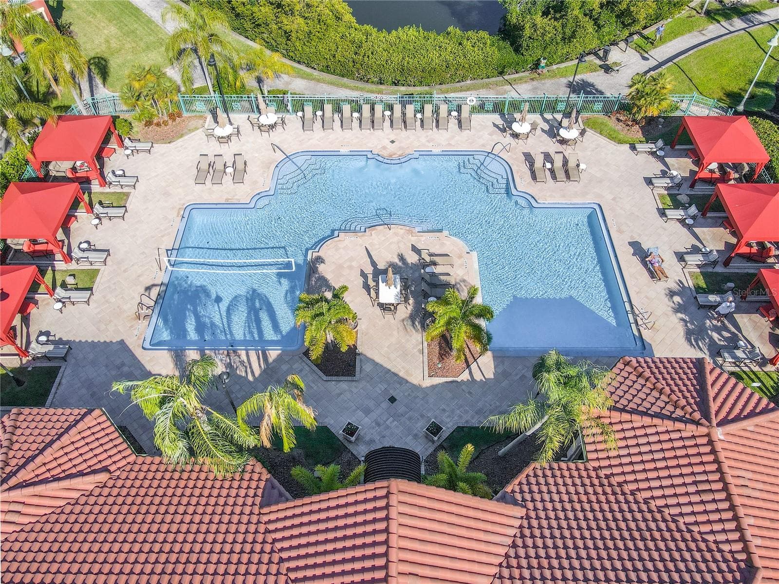 Resort-style heated clubhouse pool and spa with a spacious sundeck, lounge seating, and private rentable cabanas—perfect for relaxing, entertaining, and soaking up the Florida sunshine. - 2738 VIA TIVOLI #220B, CLEARWATER