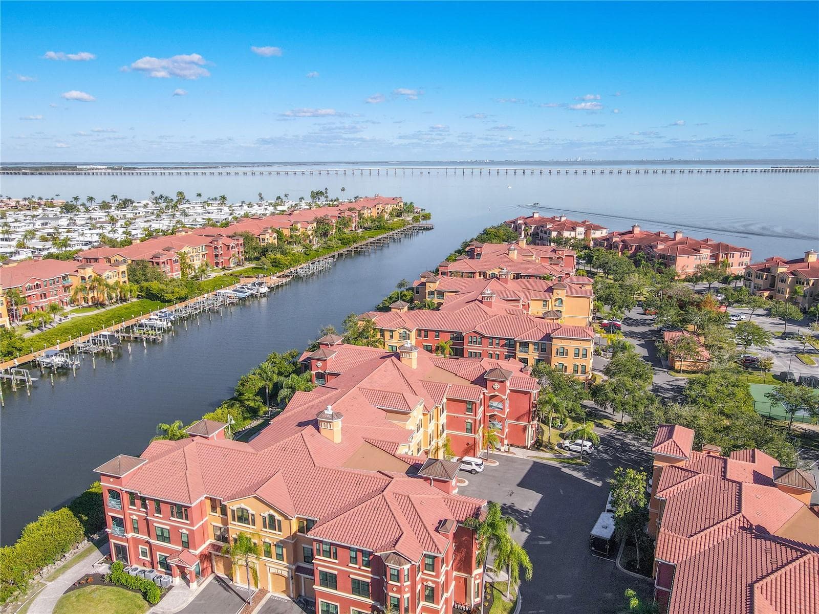 An elegant aerial captures the beautifully designed Mediterranean-style building, highlighting the second-floor corner residence within a lush, palm-lined courtyard setting. - 2738 VIA TIVOLI #220B, CLEARWATER