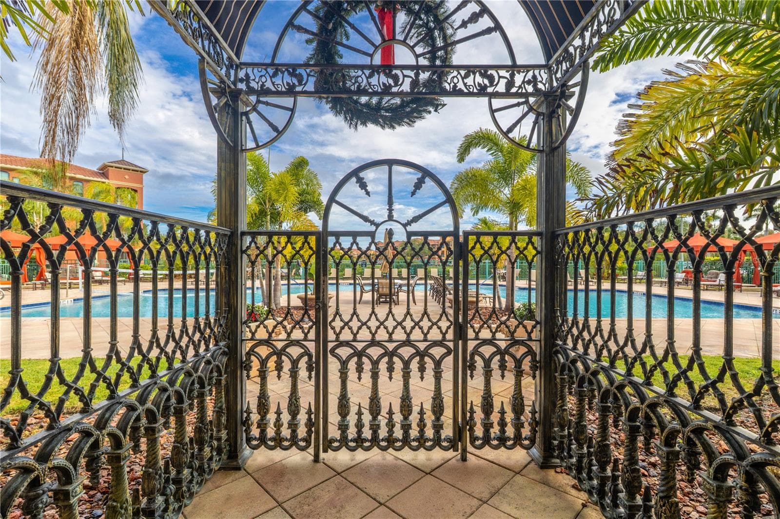 Gated entrance to the resort-style heated clubhouse pool and spa with a spacious sundeck, lounge seating, and private rentable cabanas—perfect for relaxing, entertaining, and soaking up the Florida sunshine. - 2738 VIA TIVOLI #220B, CLEARWATER