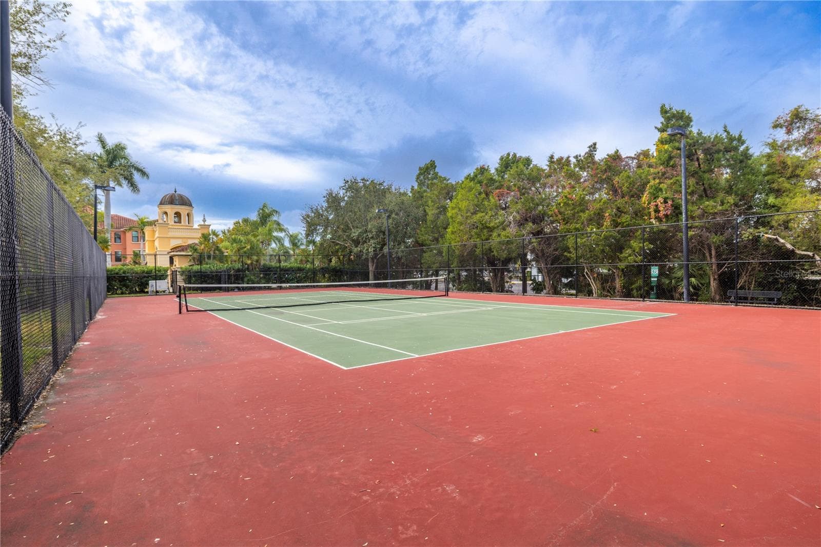 Community tennis courts set in a beautifully maintained, palm-lined setting—perfect for active living and enjoying the resort-style amenities. - 2738 VIA TIVOLI #220B, CLEARWATER