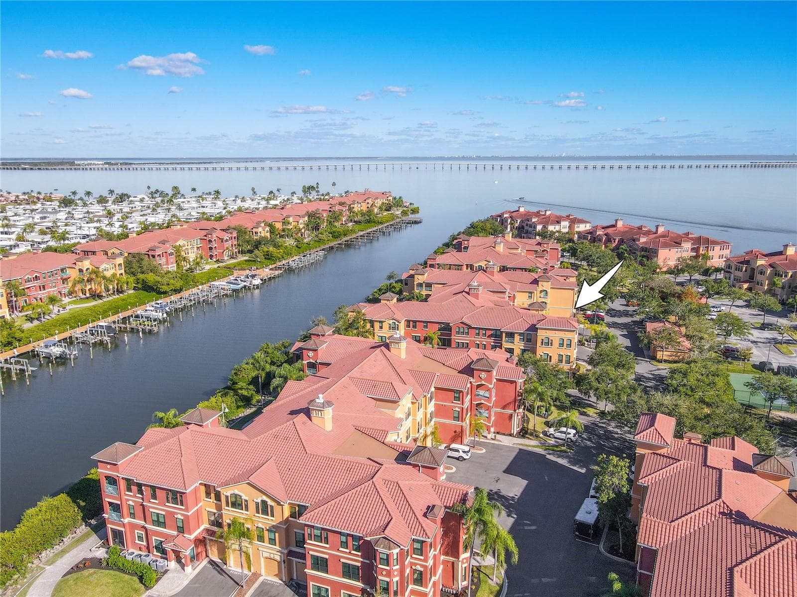 Another elevated aerial view highlights the Mediterranean-style architecture of the Grand Bellagio community, showcasing tile-roofed buildings, palm-lined grounds, and the desirable corner placement of this residence within a beautifully maintained setting. - 2738 VIA TIVOLI #220B, CLEARWATER