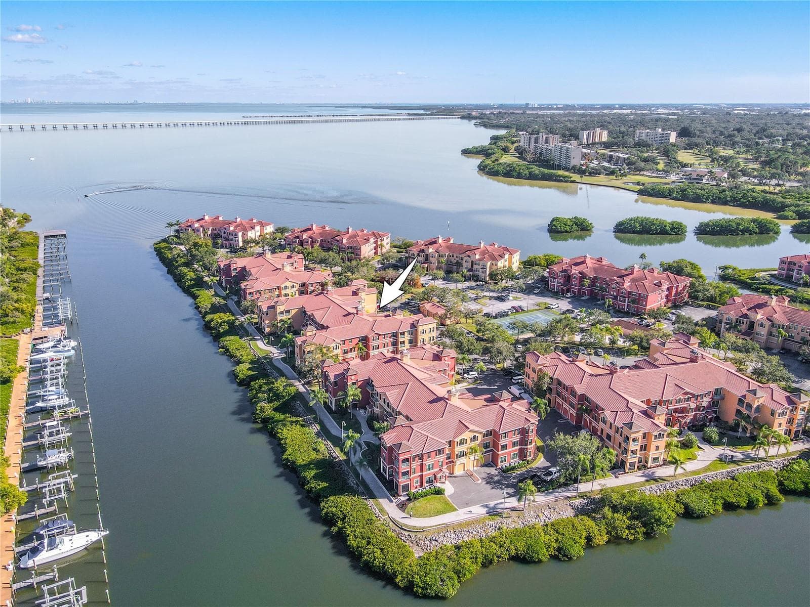 Another elevated aerial view highlights the Mediterranean-style architecture of the Grand Bellagio community, showcasing tile-roofed buildings, palm-lined grounds, and the desirable corner placement of this residence within a beautifully maintained setting. - 2738 VIA TIVOLI #220B, CLEARWATER