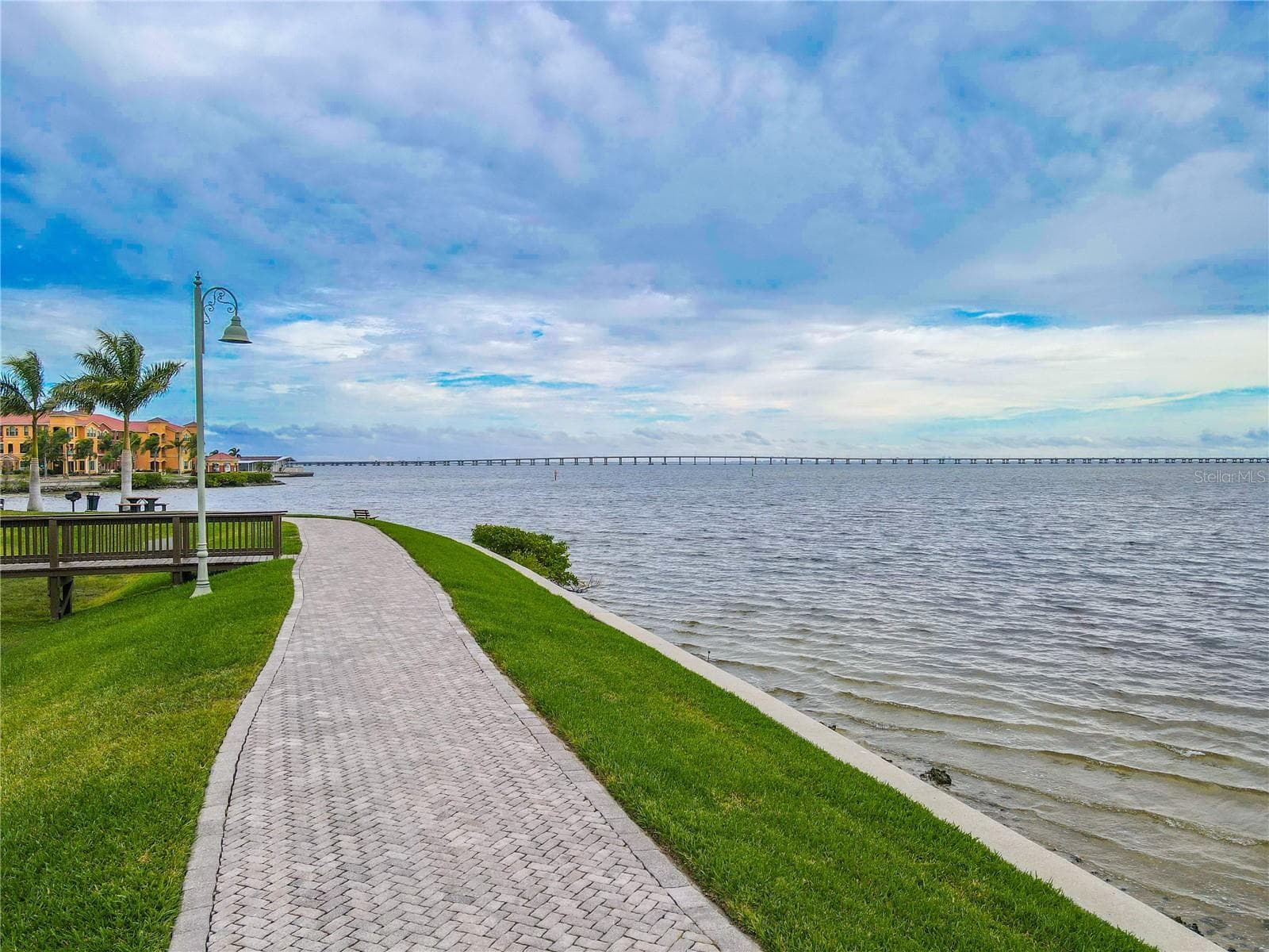Scenic waterfront promenade with a paver walking path along Old Tampa Bay, perfect for sunrise strolls, biking, and enjoying expansive water views. - 2738 VIA TIVOLI #220B, CLEARWATER