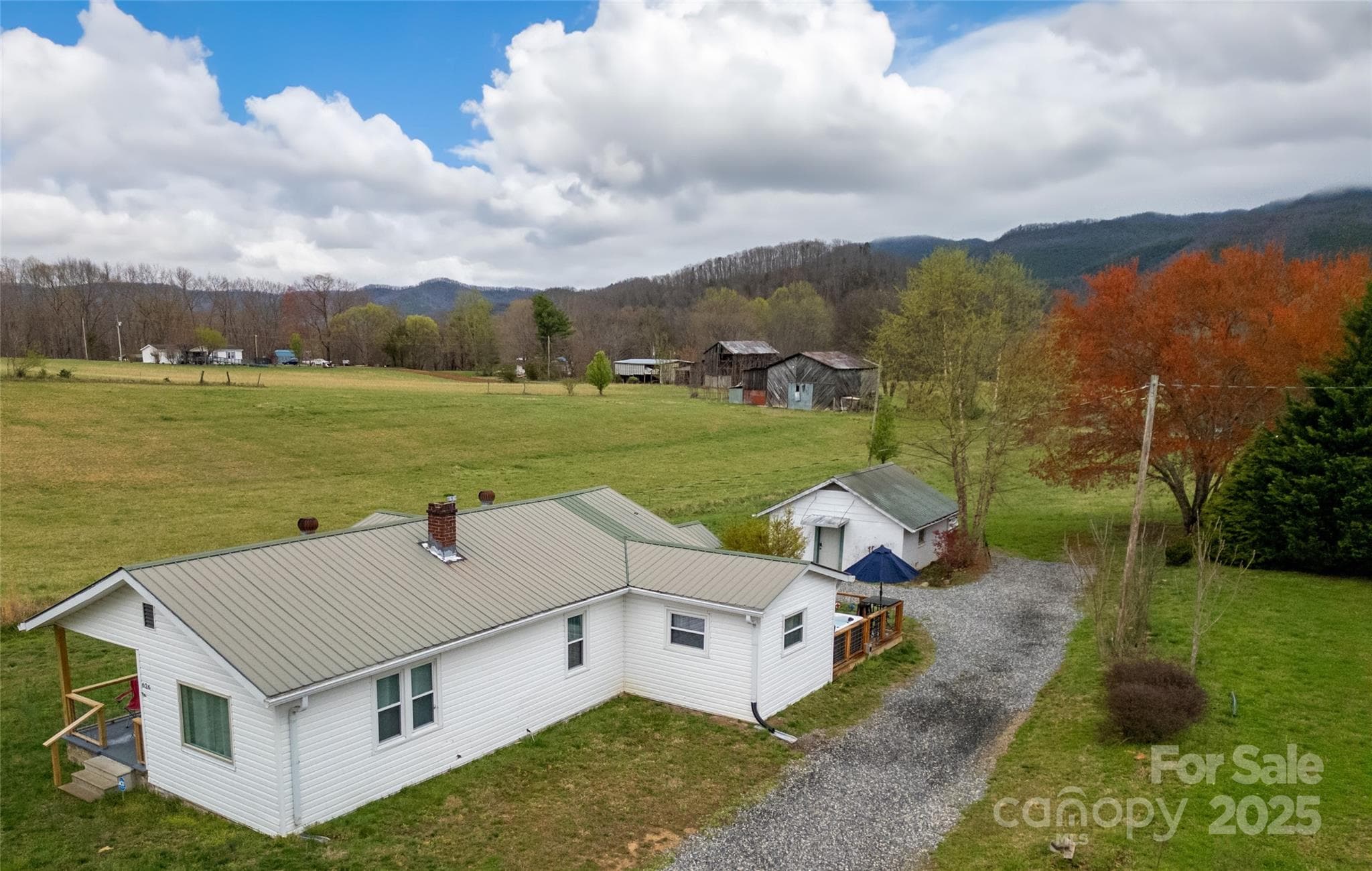 House Side from above street. Red Maple and Birch Trees in Spring. Meadow, Barns and Mountains beyond. - 626 Fairview Loop, Hot Springs