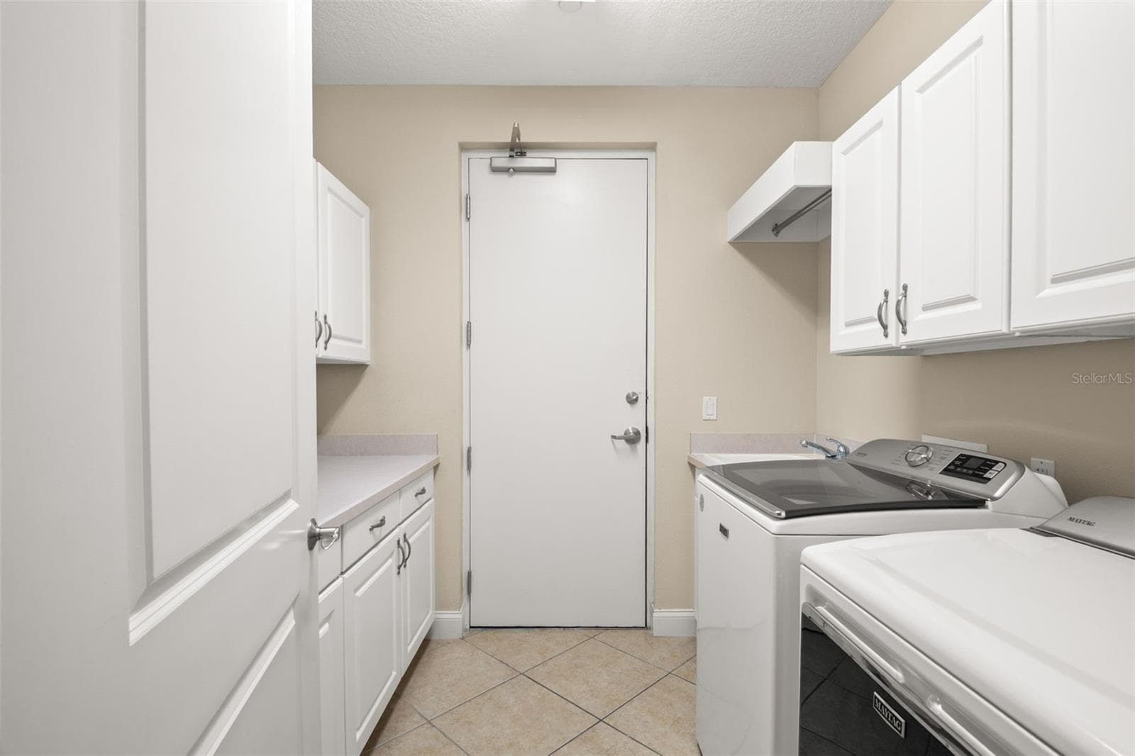 Large utility room with lots of storage, hanging space and utility sink. - 8 ACADEMY WAY S #123, ST PETERSBURG