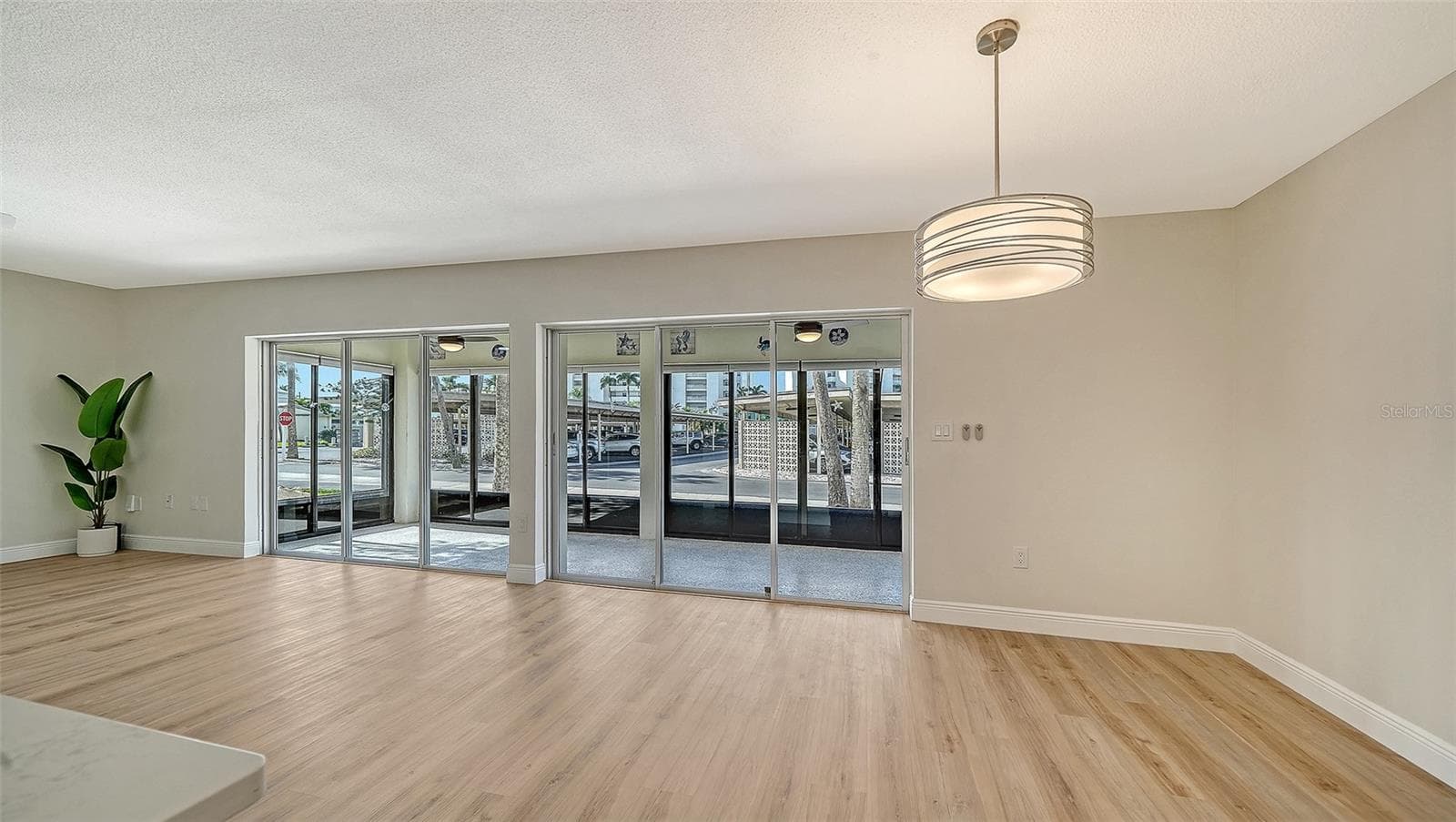 Living Room space (left) and Dining Room (right.) New overhead dining fixture. - 101 WHISPERING SANDS DR #107, SARASOTA