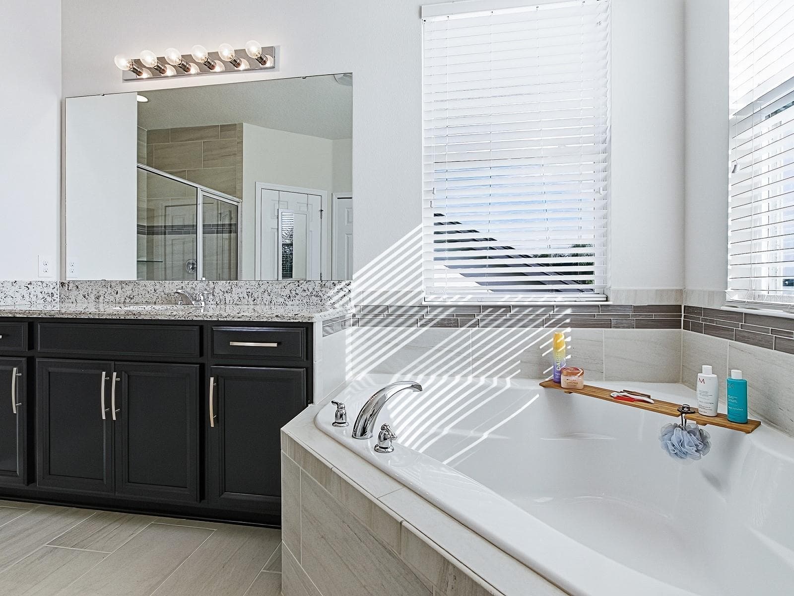 Elegant primary bath featuring dual sinks, a deep soaking tub, and a walk-in shower. - 417 BLUE CYPRESS DR, GROVELAND