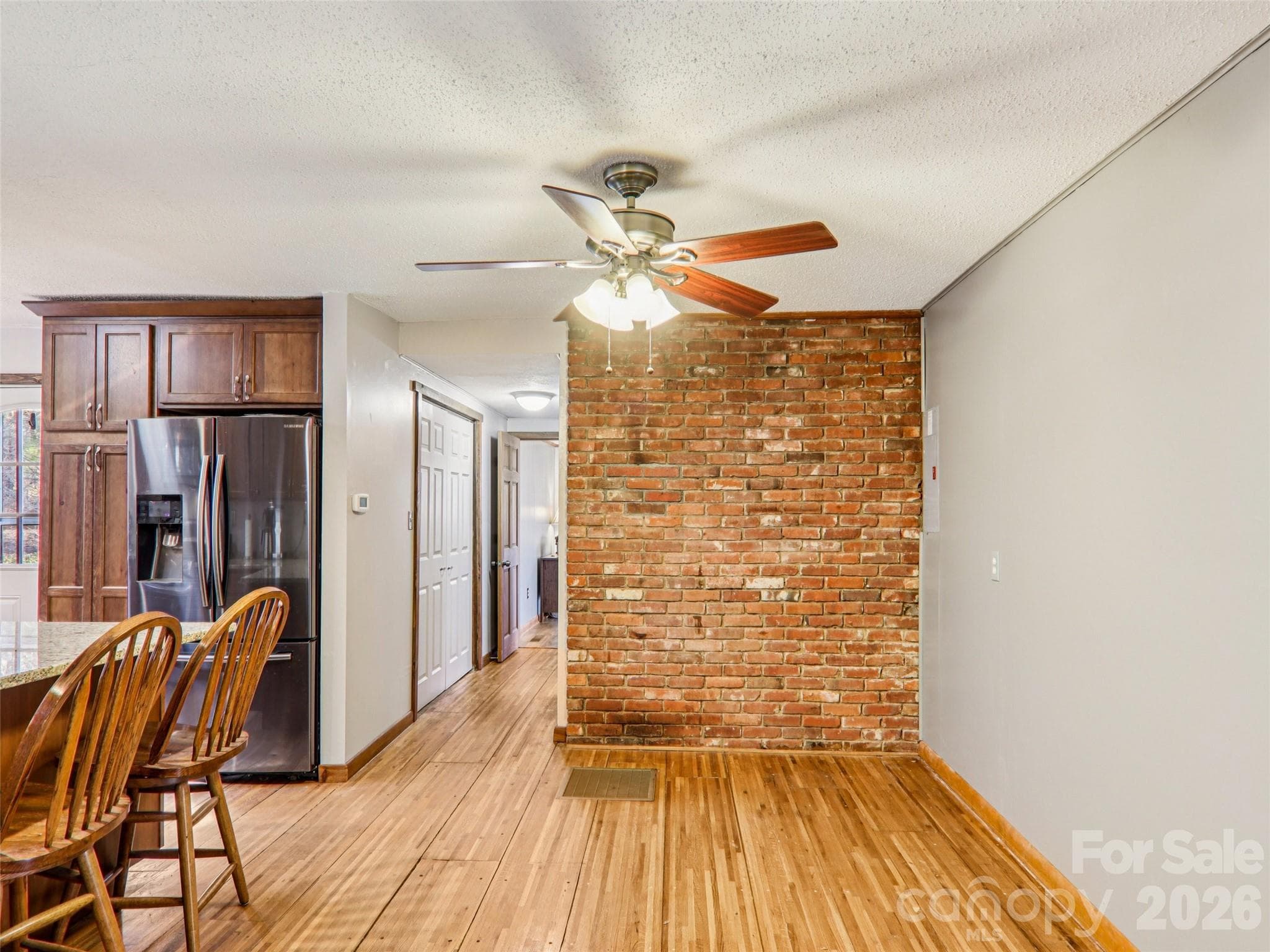 Dining area adjacent to the kitchen, with sightlines down the hallway leading to the laundry closet and third bedroom with deck access, highlighting the home’s functional layout and natural flow. - 7 Landon Mountain Lane, Weaverville