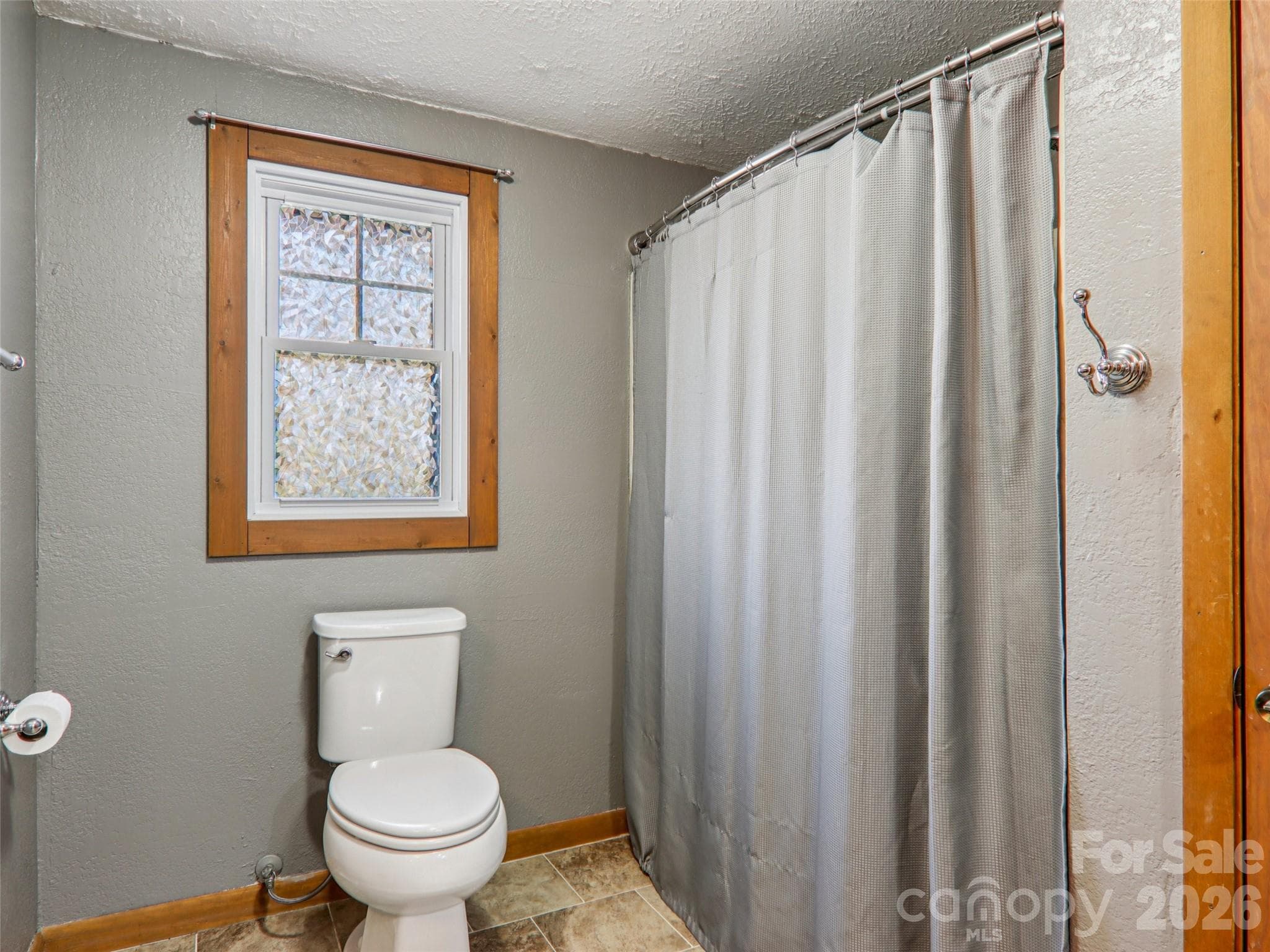 Alternate view of the second full bathroom showing the tub/shower area and window with natural light - 7 Landon Mountain Lane, Weaverville