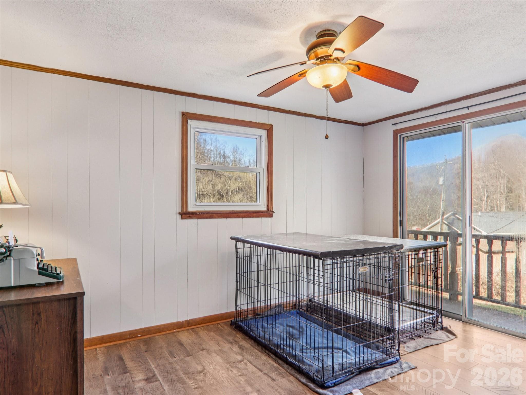 Bedroom 3 with luxury vinyl plank flooring, ceiling fan, and direct access to the deck via sliding glass door - 7 Landon Mountain Lane, Weaverville