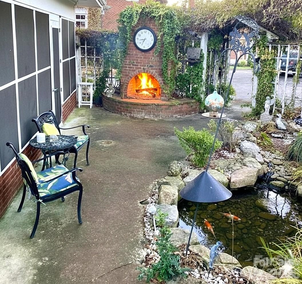 Rear patio with outdoor fireplace and water feature. - 1051 Pee Dee Avenue, Albemarle