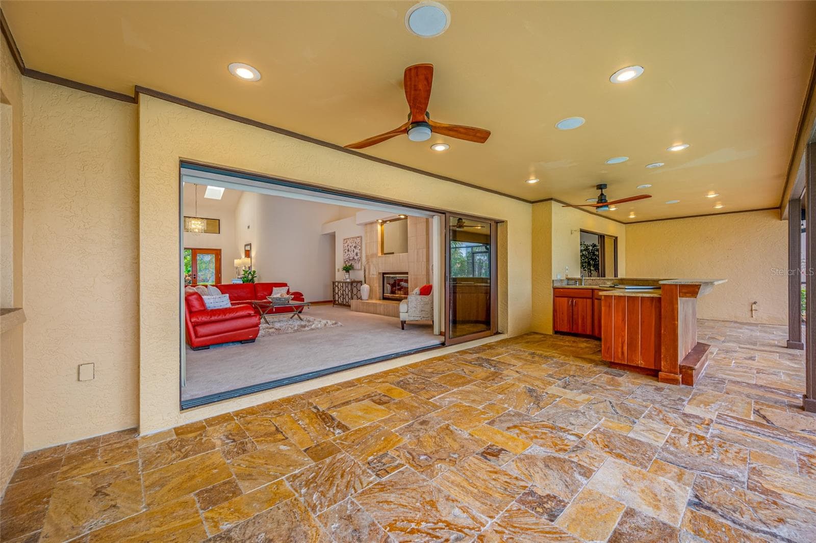 Lanai view of full outdoor kitchen and grill, showing living room with triple sliders - 9807 COMPASS POINT WAY, TAMPA
