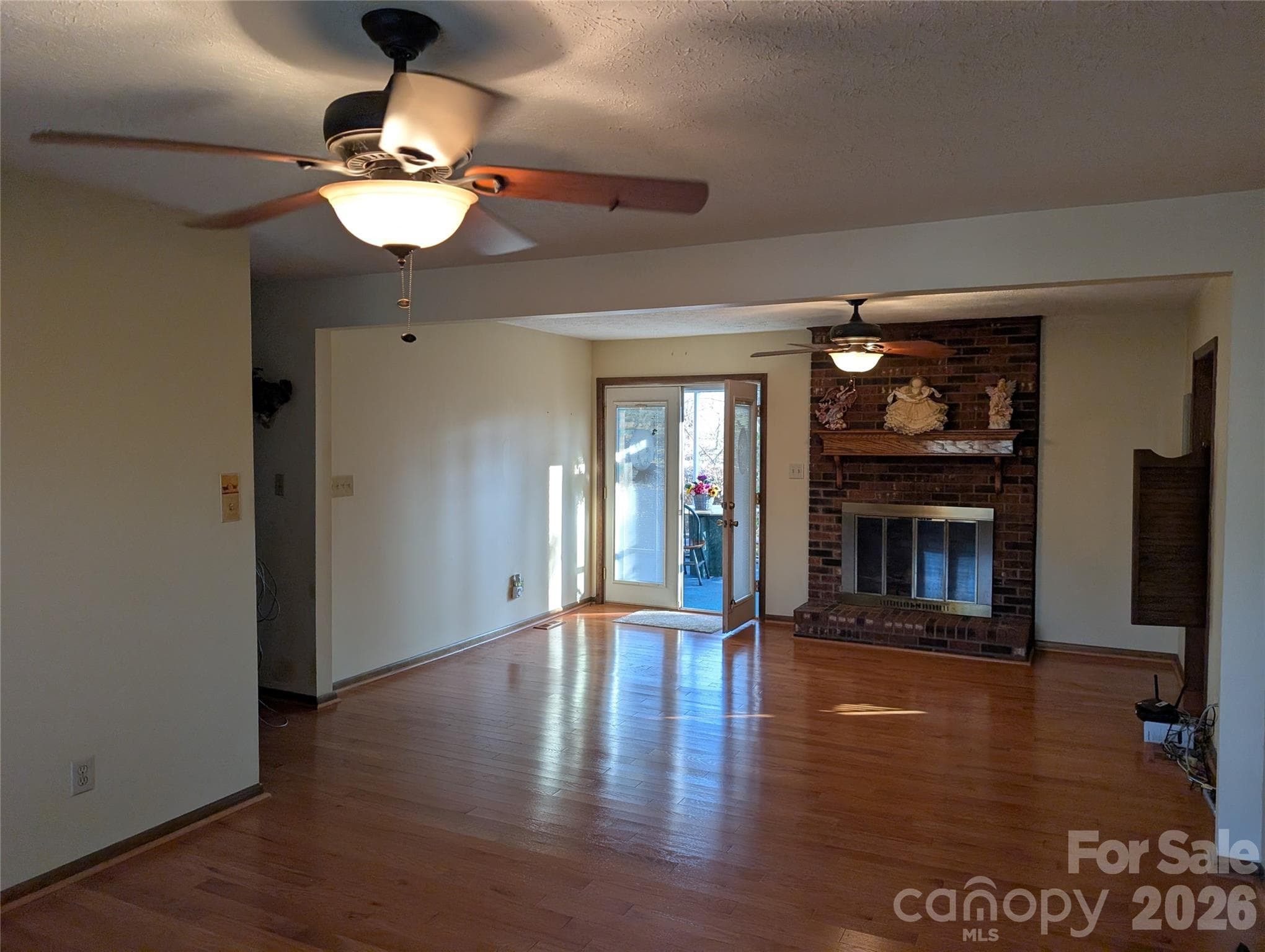 Living area which is 40" long, with gas brick fireplace and French doors to the 12x12 screened porch - 3065 Woodstream Drive, Valdese