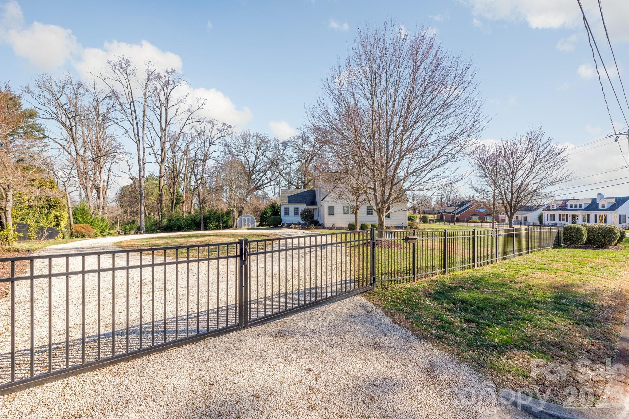 Gated entrance to a circular pea gravel driveway in the large 0.75 acre lot - 27 Circle Drive, Belmont