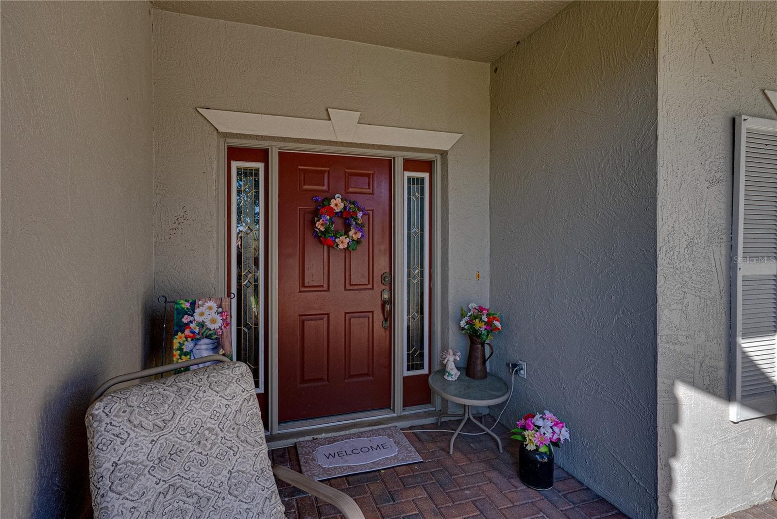 The covered front entry. The front door sidelights allow natural light for the welcoming foyer inside. - 4360 ASHTON CLUB DR, LAKE WALES