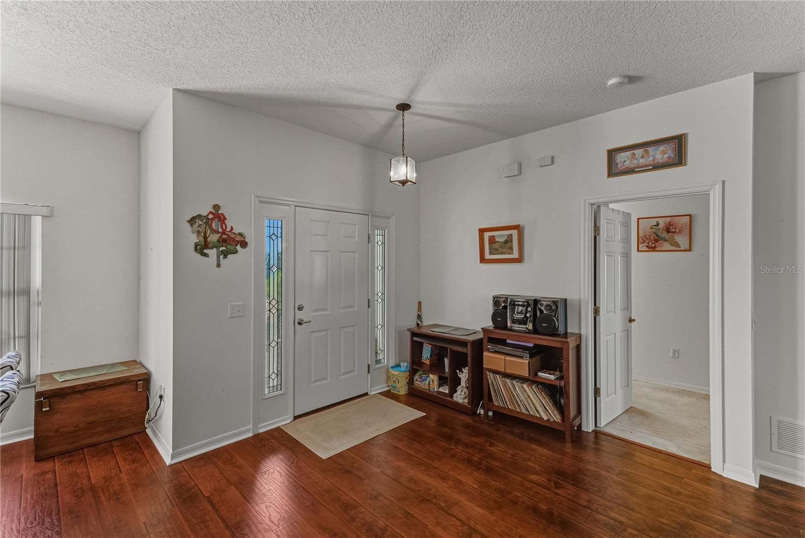 The foyer also has the doorway to the primary suite that occupies the entire south wing of this home. - 4360 ASHTON CLUB DR, LAKE WALES