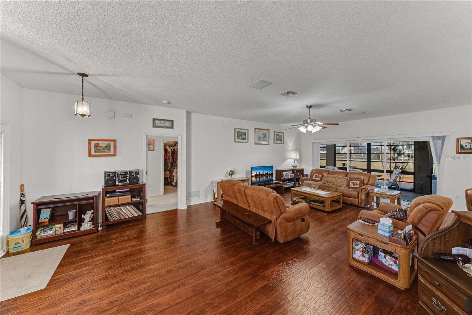 The living room has luxury vinyl plank flooring and a ceiling fan with light. - 4360 ASHTON CLUB DR, LAKE WALES