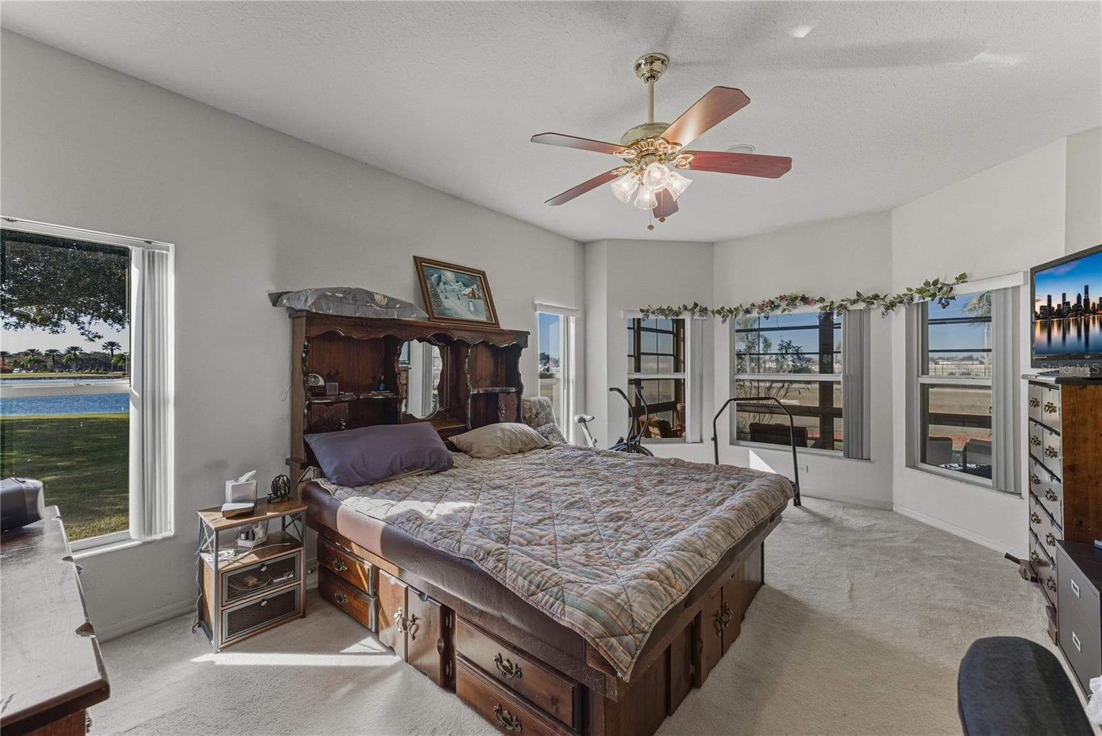 The primary bedroom is at the rear of the home and has carpeting and a ceiling fan with light. - 4360 ASHTON CLUB DR, LAKE WALES
